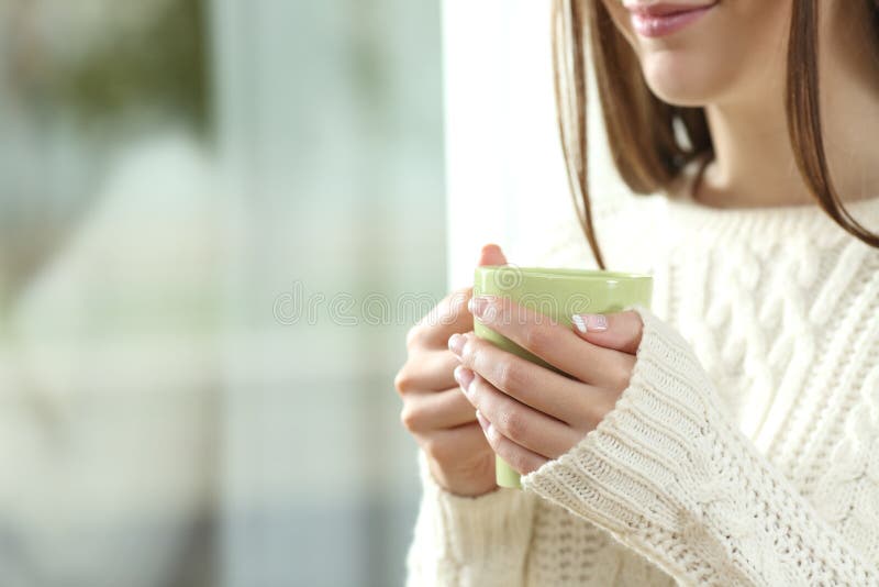 Frau übergibt das Halten einer heißen Kaffeetasse im Winter