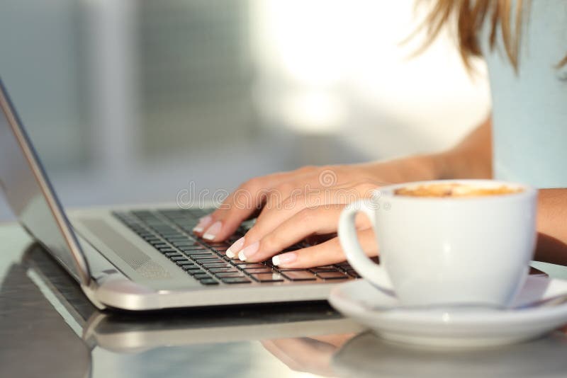 Frau übergibt das Schreiben in einem Laptop in einer Kaffeestube