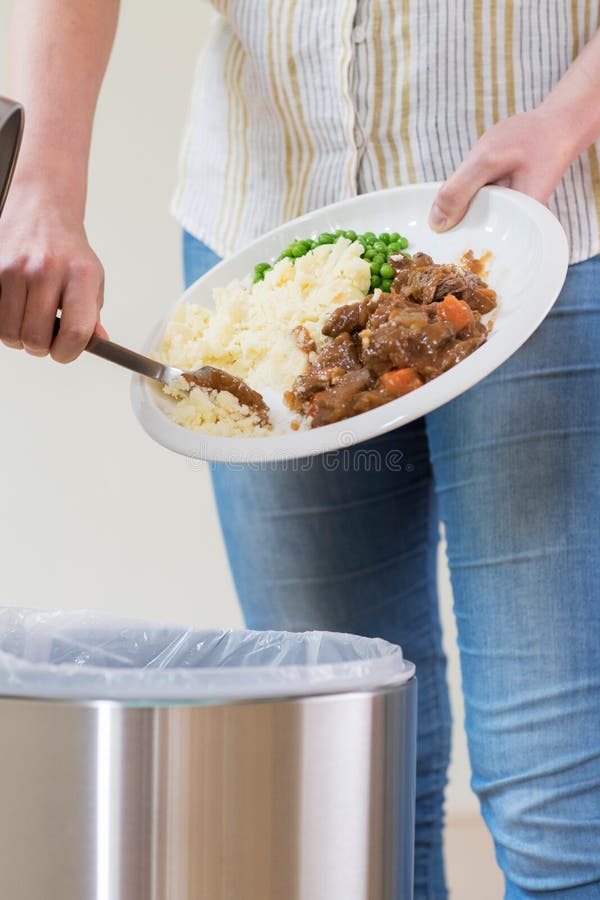 Frauen-Abfalllebensmittel-Reste in Mülltonne lizenzfreie stockfotos Frauen-Abfalllebensmittel-Reste in Mülltonne lizenzfreie stockfotos