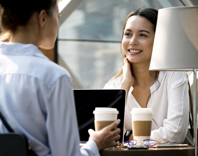 Frauen, die etwas Morgenkaffee an der Kaffeestube genießen lizenzfreie stockfotos