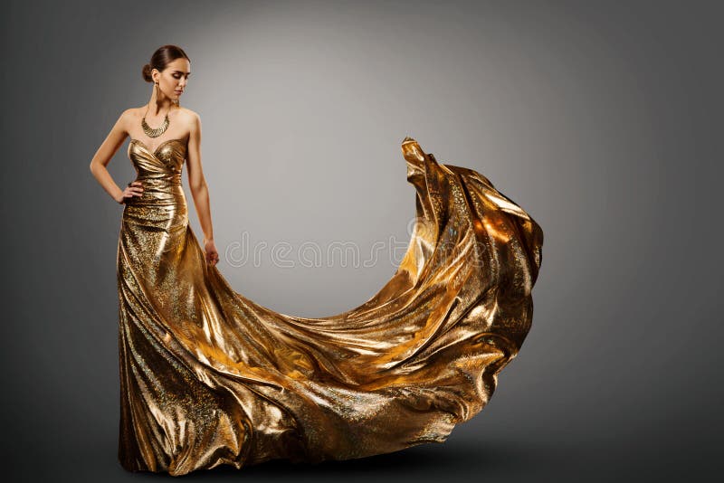 Frauen-Goldkleid, Mode-Modell im langen wellenartig bewegenden Kleid, junges Mädchen-Schönheit