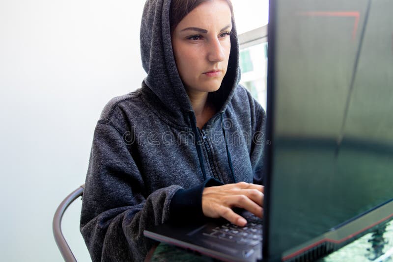 Frauen-Hackerprogrammierer arbeitet an Computer in der Internetsicherheitsmitte, die mit Bildschirmen gefüllt wird stockfoto