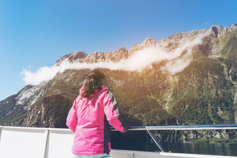 Frauen-Tourist auf Schiffs-Plattform in Milford Sound lizenzfreie stockfotografie Frauen-Tourist auf Schiffs-Plattform in Milford Sound lizenzfreie stockfotografie
