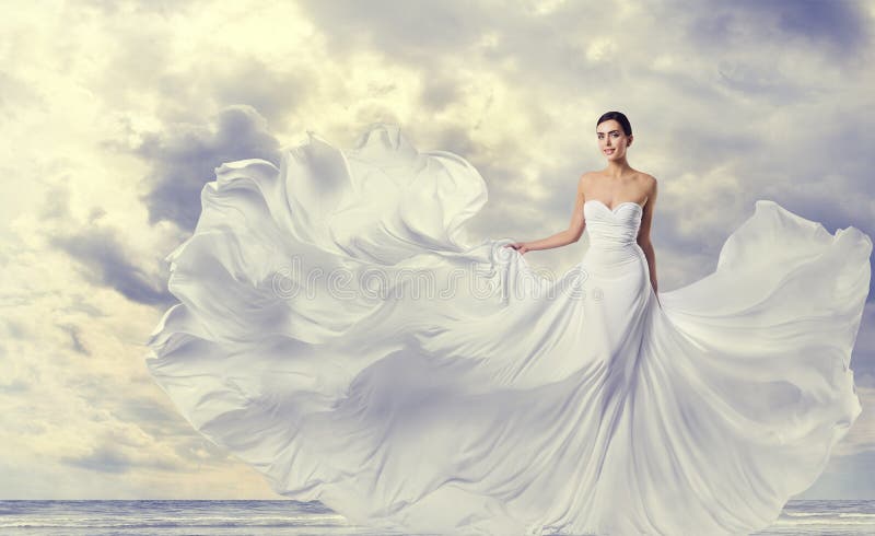 Frauen-weißes Kleid, Mode-Modell in lange Seiden-flatterndem Kleid, wellenartig bewegender fliegender Stoff auf Wind