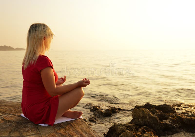 Frauen-übendes Yoga durch das Meer lizenzfreie stockfotografie Frauen-übendes Yoga durch das Meer lizenzfreie stockfotografie