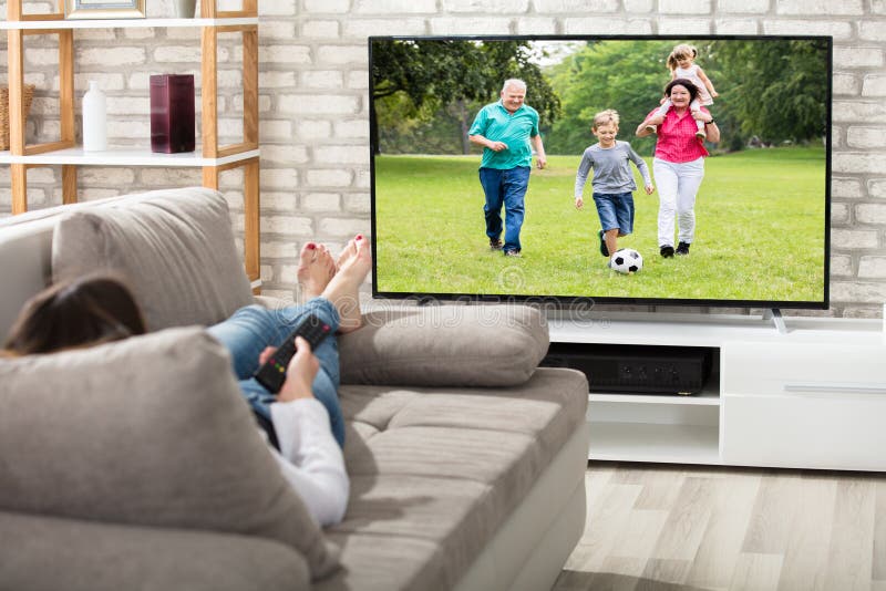 Frauen-überwachendes Fernsehen lizenzfreie stockfotografie