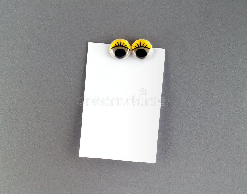 cute eyeball magnetic and notepaper for writing message to communicate and reminder, close-up with copy space for text. cute eyeball magnetic and notepaper for writing message to communicate and reminder, close-up with copy space for text