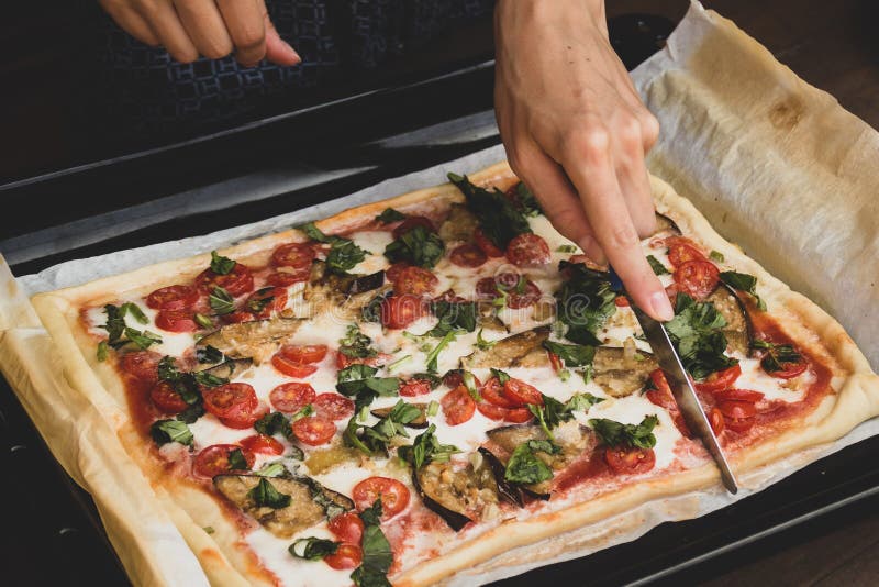 Frauenausschnitt durch rechteckige Form des Messers und traditionelle italienische Nahaufnahme margherita Pizza der Pizza der sta stockbild Frauenausschnitt durch rechteckige Form des Messers und traditionelle italienische Nahaufnahme margherita Pizza der Pizza der sta stockbild