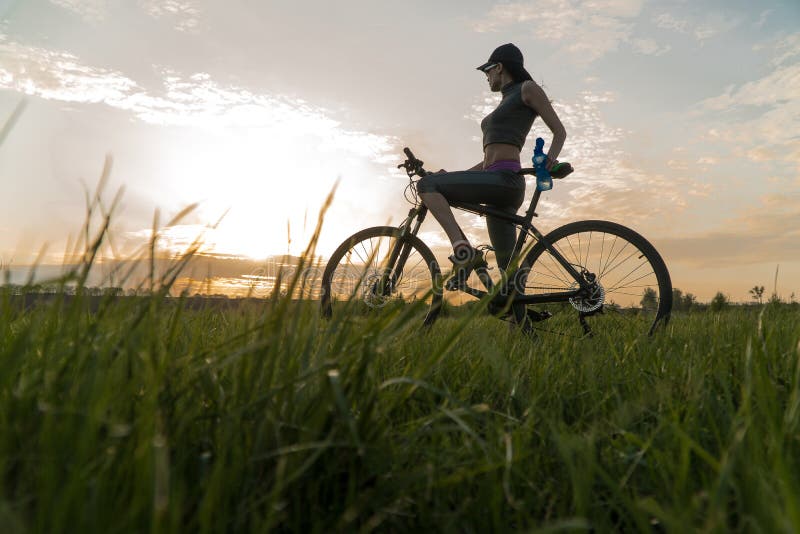 Frauenfahrradsonnenuntergang ?bung bei Sonnenuntergang stockbild Frauenfahrradsonnenuntergang ?bung bei Sonnenuntergang stockbild
