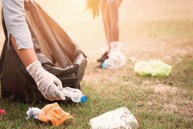 woman hand picking up garbage plastic for cleaning at park. woman hand picking up garbage plastic for cleaning at park