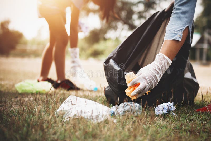 woman hand picking up garbage plastic for cleaning at park. woman hand picking up garbage plastic for cleaning at park