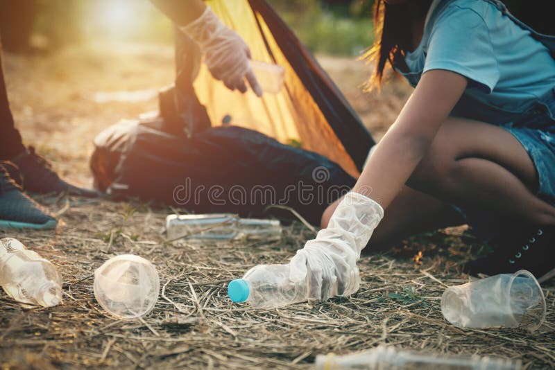 woman hand picking up garbage plastic bottle for cleaning at park. woman hand picking up garbage plastic bottle for cleaning at park