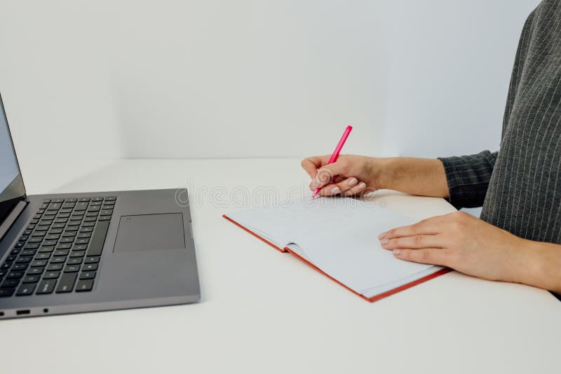 Frauenhandschrift im Notebook mit Draufsicht des Notebooks stockfotografie