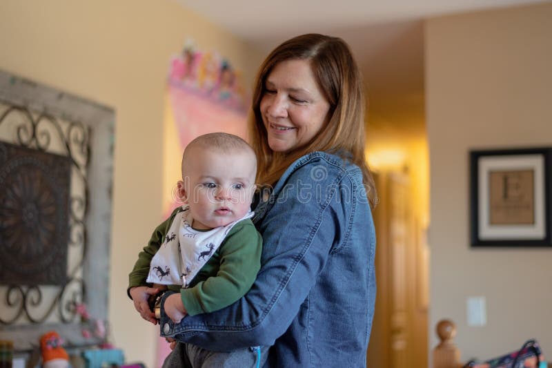 Frauenholdingbaby beim Besuchen mit Familie lizenzfreies stockfoto Frauenholdingbaby beim Besuchen mit Familie lizenzfreies stockfoto
