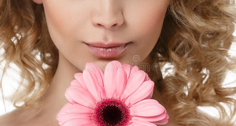 Frauenlippen riechen Kinnschönheitsporträt mit Blume im gelockten blonden Haar des Haares lizenzfreie stockfotos Frauenlippen riechen Kinnschönheitsporträt mit Blume im gelockten blonden Haar des Haares lizenzfreie stockfotos