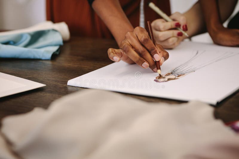 Frauenmodedesigner, die Designe auf Zeichenpapier machen stockfoto Frauenmodedesigner, die Designe auf Zeichenpapier machen stockfoto