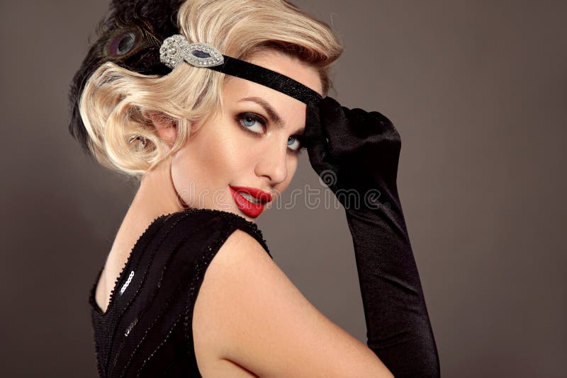 Retro woman portrait. Blonde wavy hairstyle. Hollywood red lips makeup. Curly hair style. Beautiful elegant female wears in vintage dress isolated on gray studio background. Retro woman portrait. Blonde wavy hairstyle. Hollywood red lips makeup. Curly hair style. Beautiful elegant female wears in vintage dress isolated on gray studio background