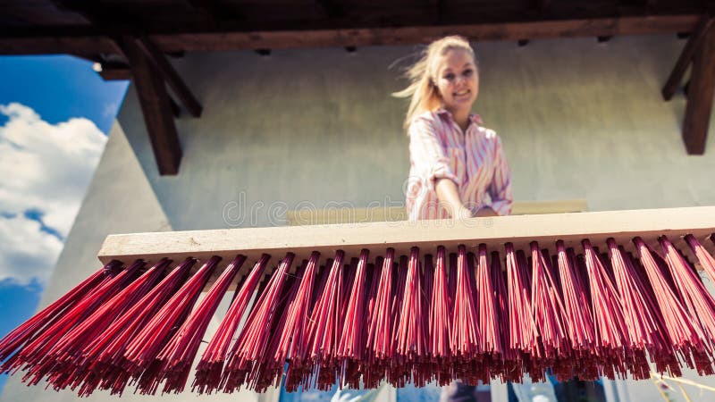 Frauenreinigungspatio unter Verwendung des B?rstenbesens stockfoto Frauenreinigungspatio unter Verwendung des B?rstenbesens stockfoto