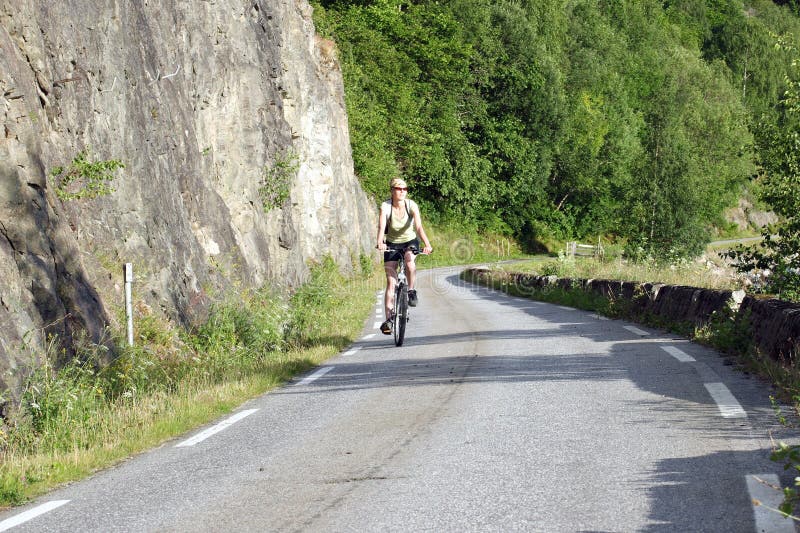 Frauenreiten auf Fahrrad lizenzfreies stockbild Frauenreiten auf Fahrrad lizenzfreies stockbild
