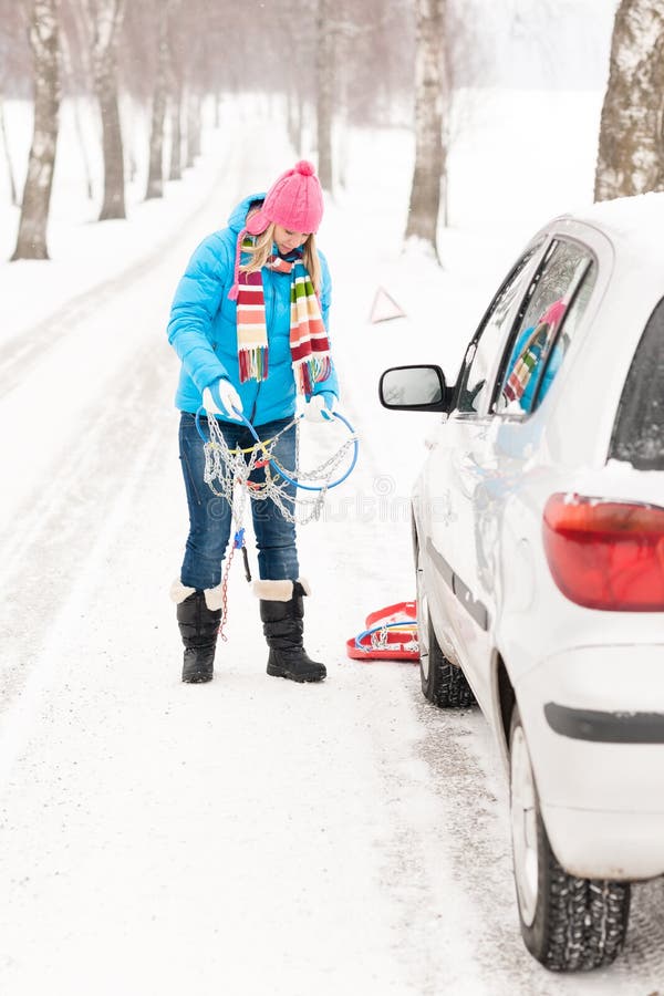 Frauenschnee, der mit Autoreifenketten steht lizenzfreies stockfoto Frauenschnee, der mit Autoreifenketten steht lizenzfreies stockfoto