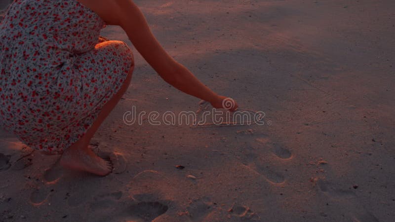 Frauenzeichnungsherz auf Sand