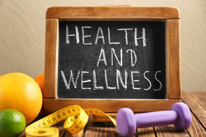 Frazuje „, zdrowie i wellness” „pisać na blackboard, owoc i dumbbell na drewnianym stole, obraz royalty free Frazuje „, zdrowie i wellness” „pisać na blackboard, owoc i dumbbell na drewnianym stole, obraz royalty free