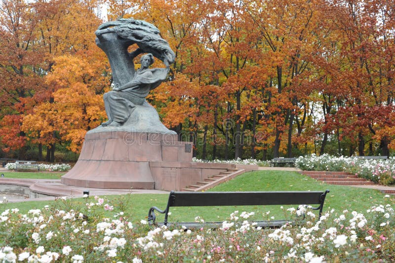 Frederic Chopin statue monument in Lazienki Royal Baths Park in Warsaw, Poland in autumn with foilage on the trees