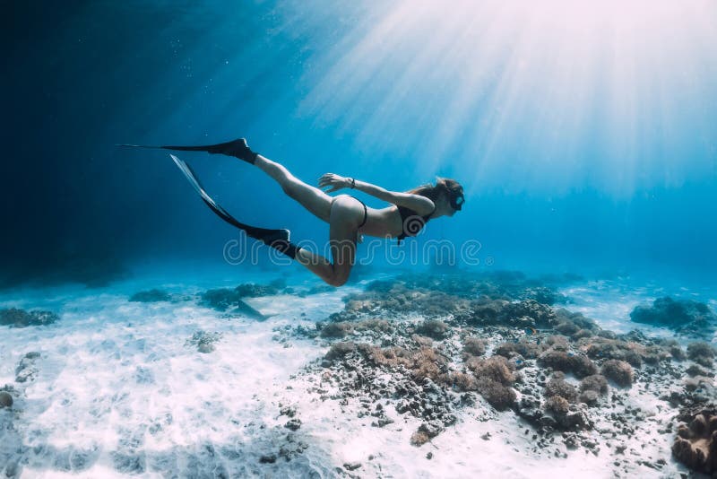 Free diver glides over sandy sea with fins. Freediving in blue sea royalty free stock image Free diver glides over sandy sea with fins. Freediving in blue sea royalty free stock image