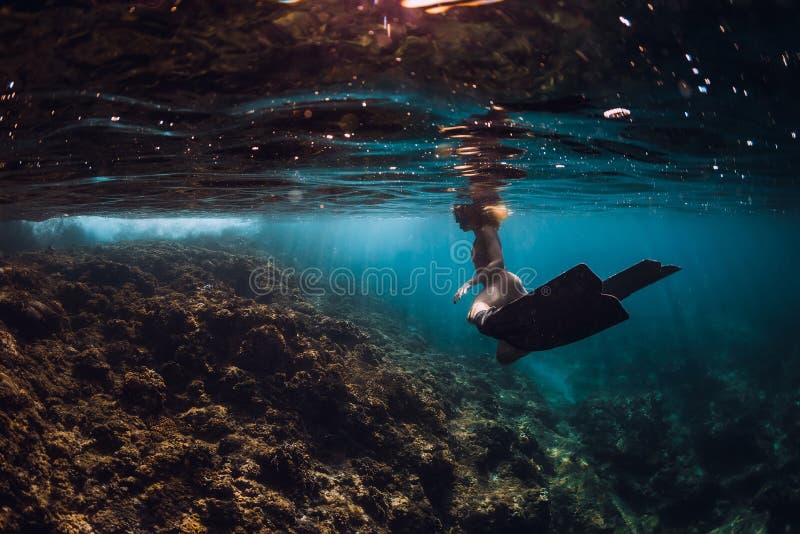 Free diver woman with fins over coral bottom. Freediving underwater in ocean royalty free stock photo Free diver woman with fins over coral bottom. Freediving underwater in ocean royalty free stock photo