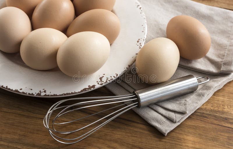 Free range eggs in bowl, whisk, napkin.