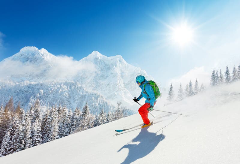 Free-ride skier in fresh powder snow running downhill