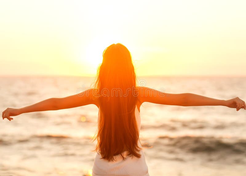 Free woman enjoying freedom feeling happy at beach at sunset. Be