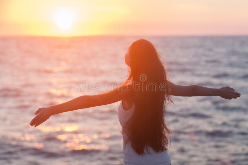 Omaggio donna godere di un senso di libertà felice in spiaggia al tramonto.