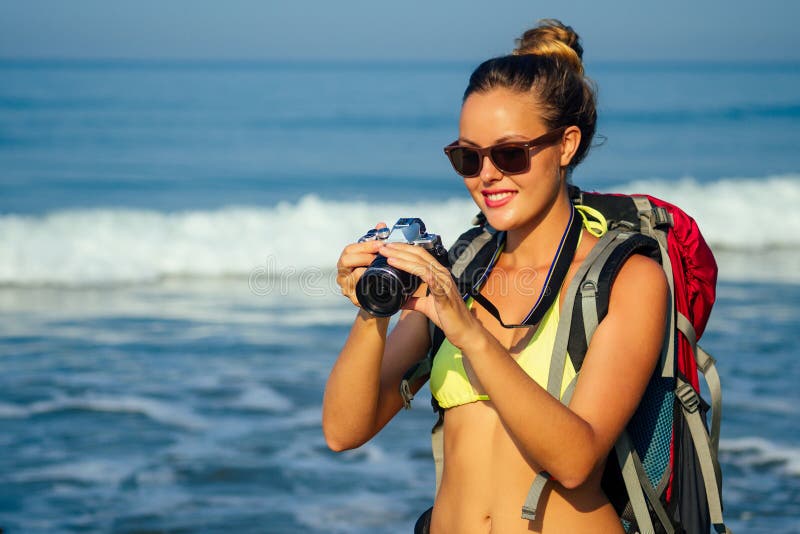 Freedom Young women backpacker in een sexy gele bikini-zwempak met een camera in hand op het strand blonde fotograaf royalty-vrije stock fotografie Freedom Young women backpacker in een sexy gele bikini-zwempak met een camera in hand op het strand blonde fotograaf royalty-vrije stock fotografie