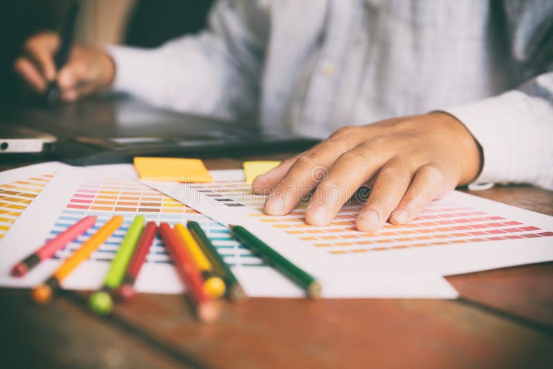 Freelance graphic designer using digital tablet, computer, man w royalty free stock images