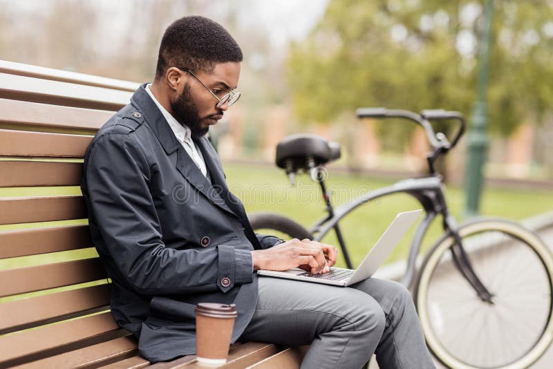 Freelance work. Man working on laptop in park