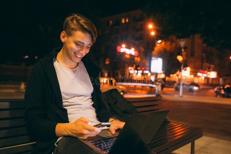 Freelancer feliz novo que trabalha na rua da cidade imagens de stock Freelancer feliz novo que trabalha na rua da cidade imagens de stock