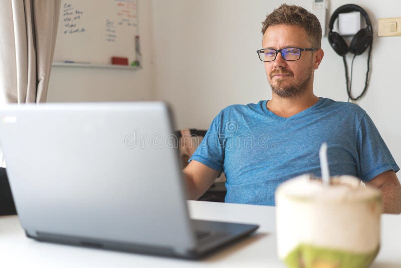 Freelancer guy with laptop working at home in quarantine to coronavirus infection royalty free stock photos Freelancer guy with laptop working at home in quarantine to coronavirus infection royalty free stock photos