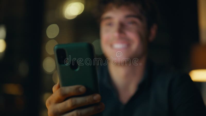 Freelancer hands holding smartphone at night workplace closeup. Smiling man stock video