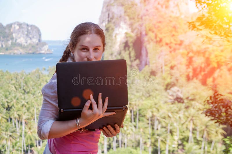 Freelancermeisje het verbergen achter het laptop scherm Zij bevindt zich op de rand van een rots met zijn terug naar het overzees stock afbeeldingen Freelancermeisje het verbergen achter het laptop scherm Zij bevindt zich op de rand van een rots met zijn terug naar het overzees stock afbeeldingen
