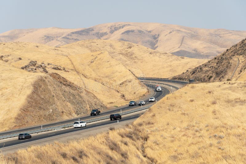 Freeway road crossing the the San Luis Reservoir valleys during dry and hot season, California, USA