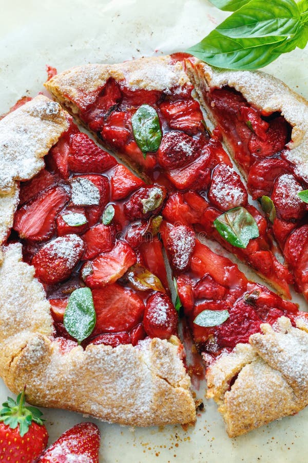 Frei-Formtorte galette mit Erdbeeren und Basilikum. Köstlicher selbst gemachter Kuchen mit Erdbeeren und Basilikum schnitten in Stücke