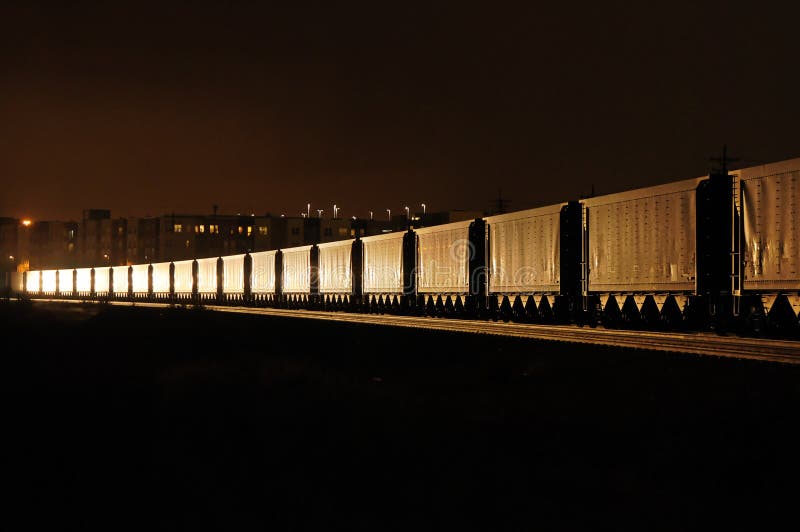 A freight train at night illuminated by the headlight of an oncoming train. Night train stock images, royalty-free photos and pictures