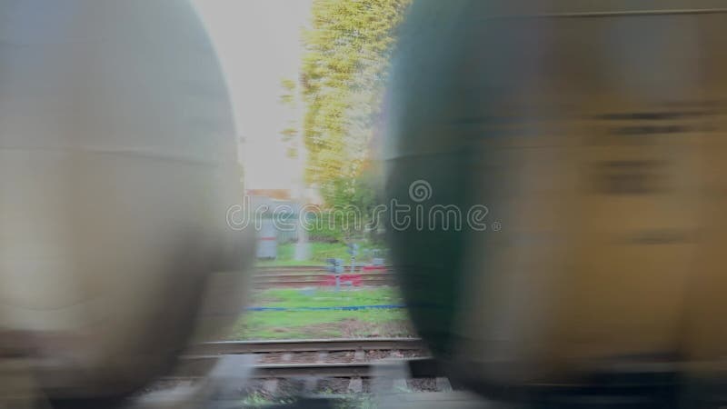 Freight train with tanks rushing past village.