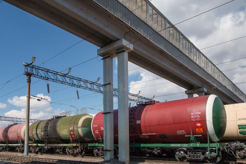 Freight Train with Tanks Stands on the Rails Under the Overpass at the