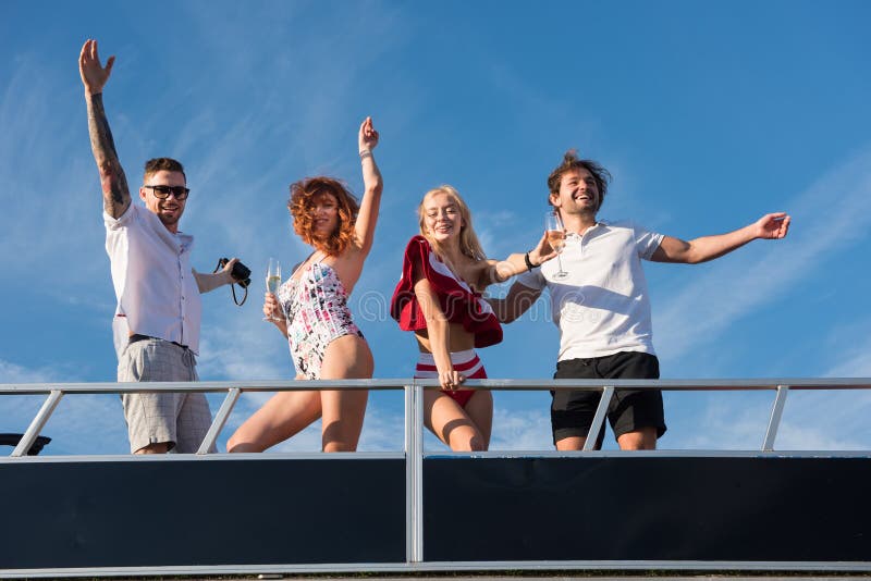 Freinds are having fun on yacht under the blue sky. 