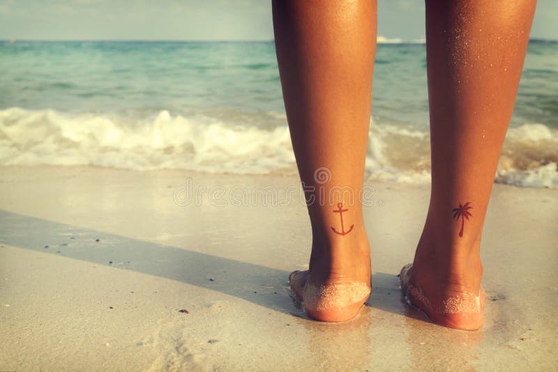 Freizeit im Sommer - Rückseite der Schönheitssonnenbräune entspannen sich auf Strand mit Tätowierung zu Fuß