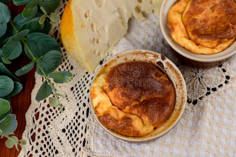French Baked Cheese Souffle in Rameken on Wood Table Stock Photo