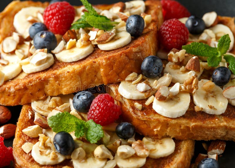 French cinnamon toast with blueberries, raspberries, banana, nuts, hazelnut and honey.