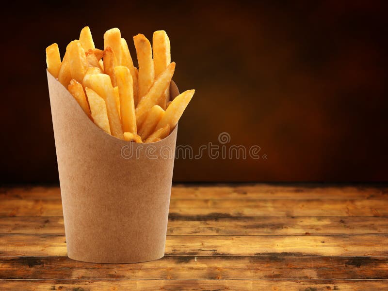 Patatine fritte in un cestino sul tavolo di legno.